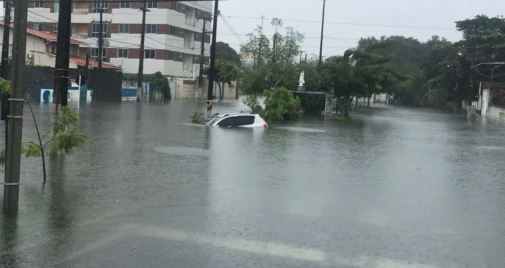  Carro fica quase submerso após alagamento na rua Dr. José Gonçalves, em Lagoa Nova